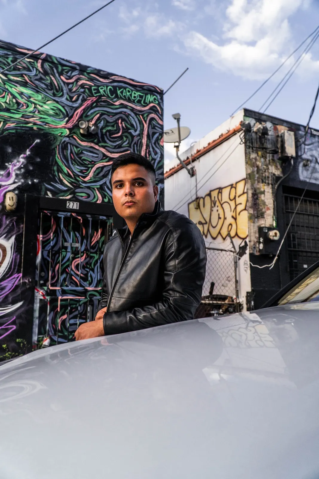 Man standing beside a colorful mural
