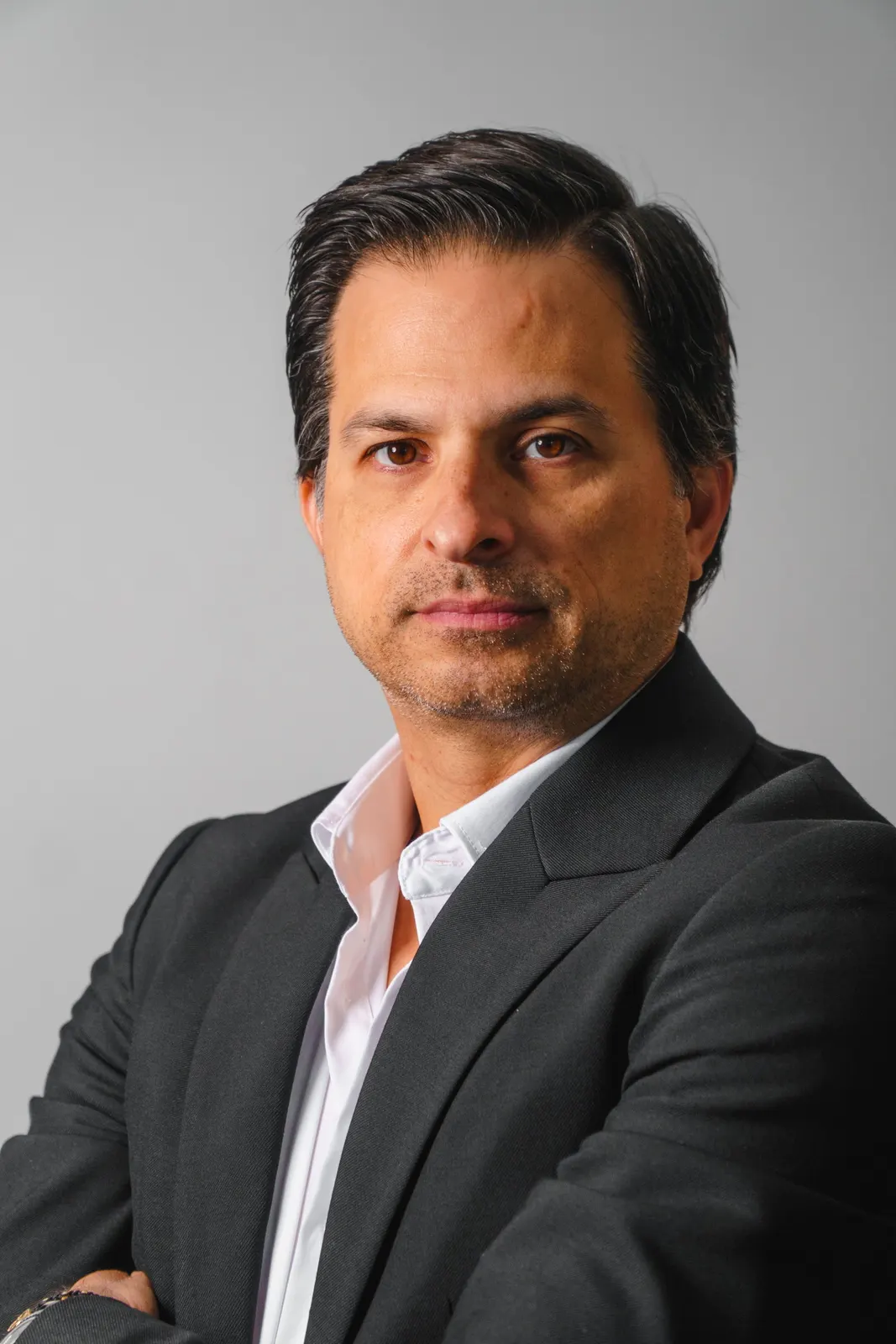 Man in a dark suit against a light background