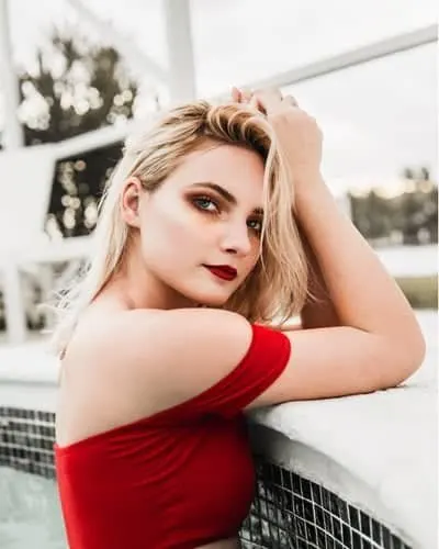 Woman in a red top leaning on a railing