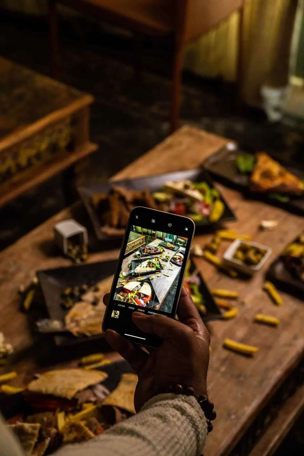 Phone photographing a meal on a restaurant table