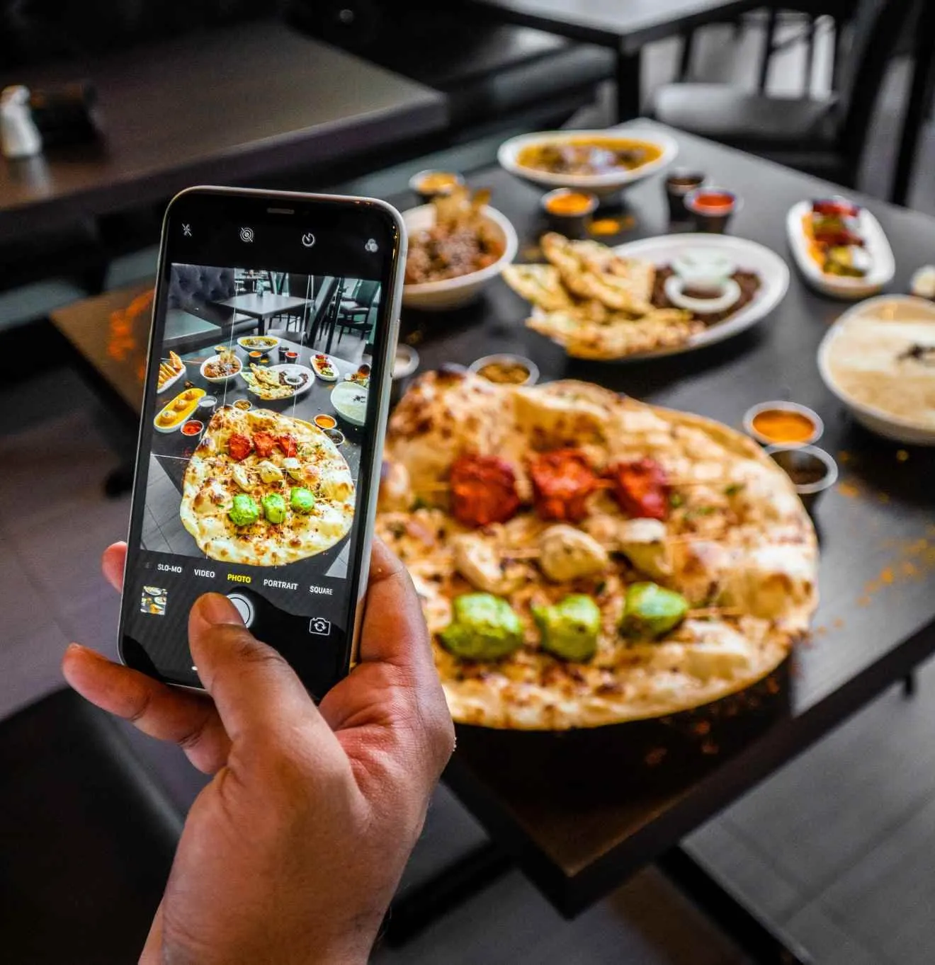 Phone photographing a spread of food on a table