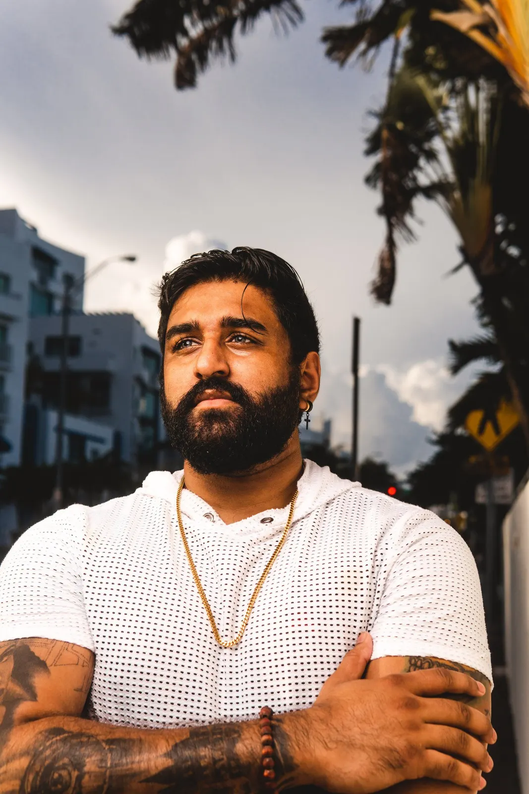 Bearded man with folded arms outdoors