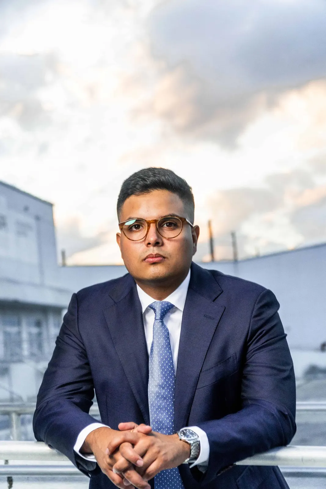 Man in a navy suit seated outdoors