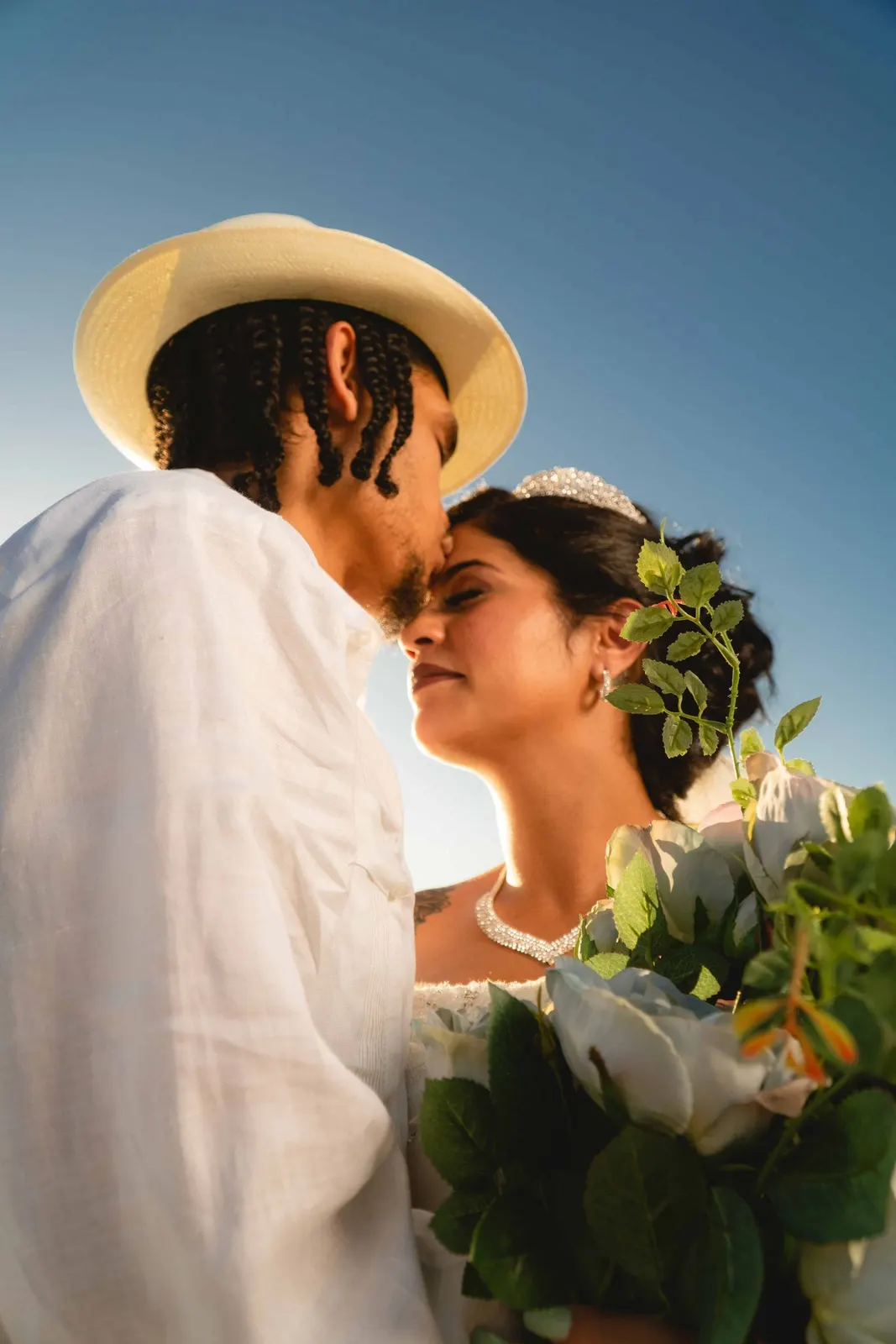 Couple embracing outdoors with a bouquet in the foreground