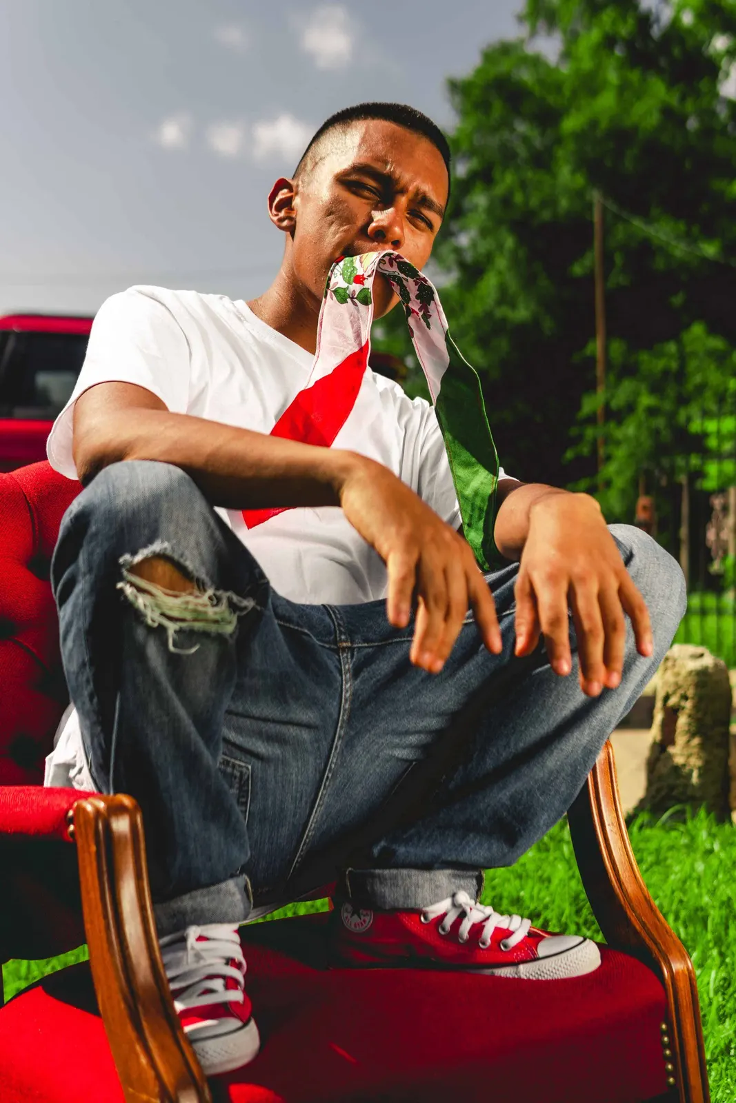 Man seated in a red chair outdoors