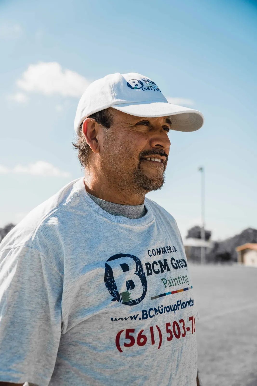 Man in a white branded shirt outdoors