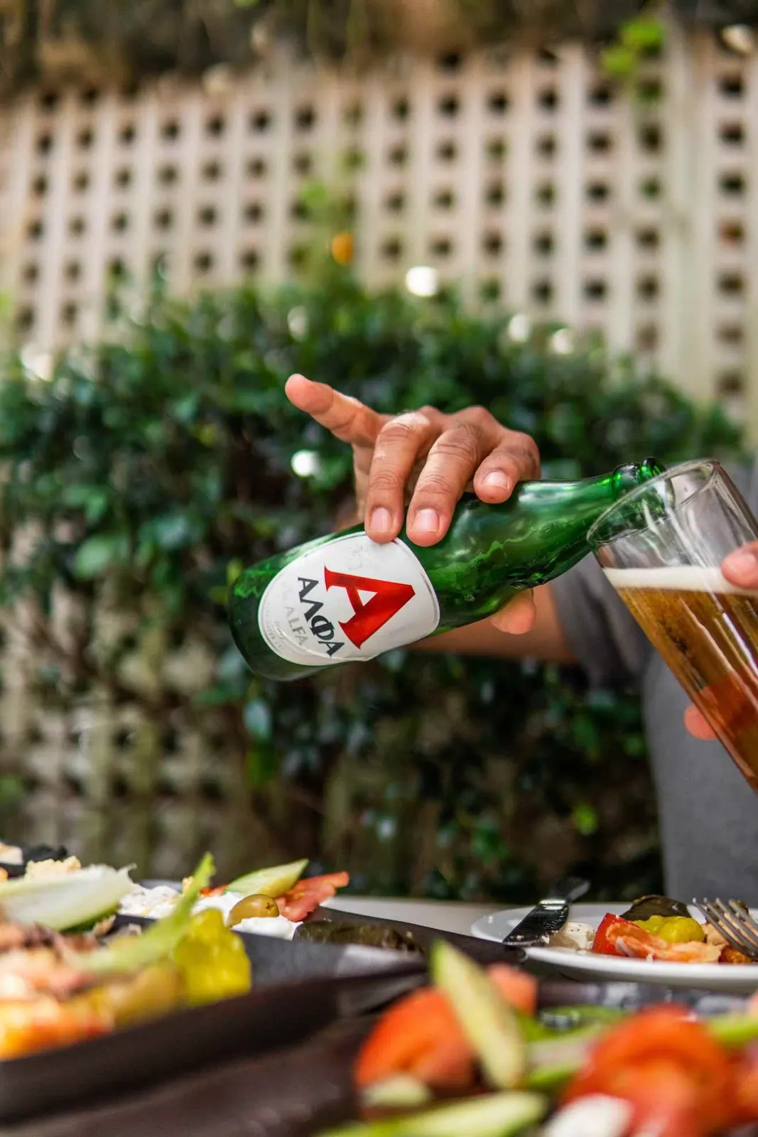 Bottle being poured over a plated meal