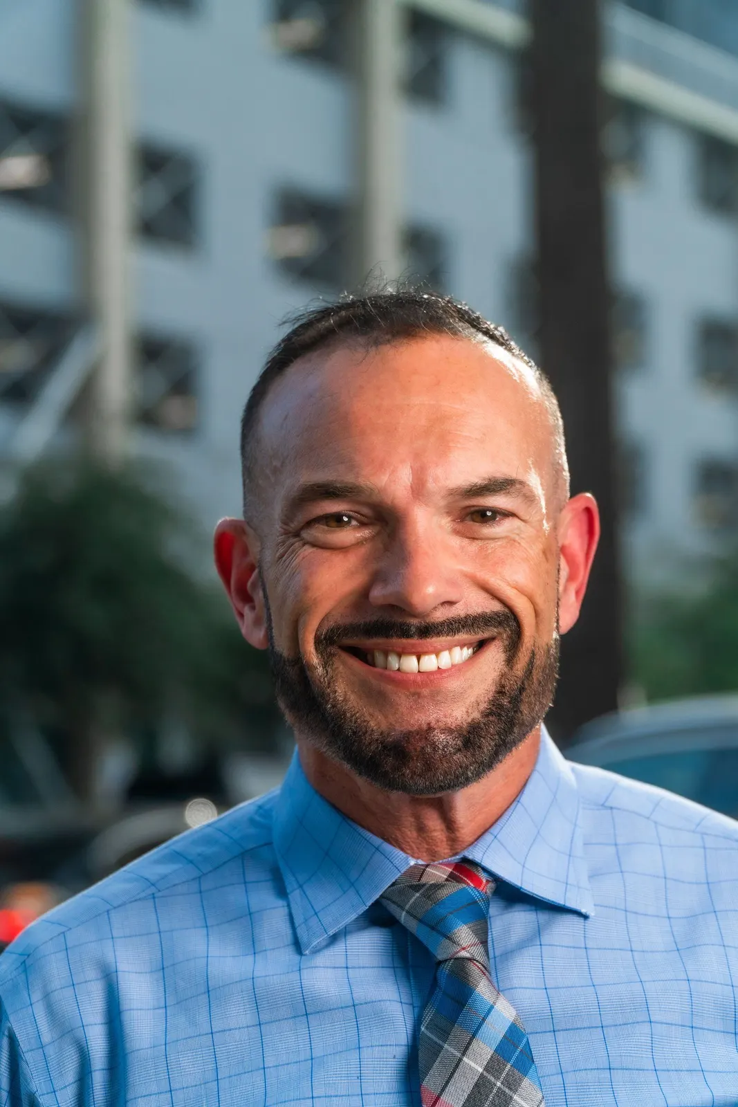 Smiling man in a blue shirt and tie