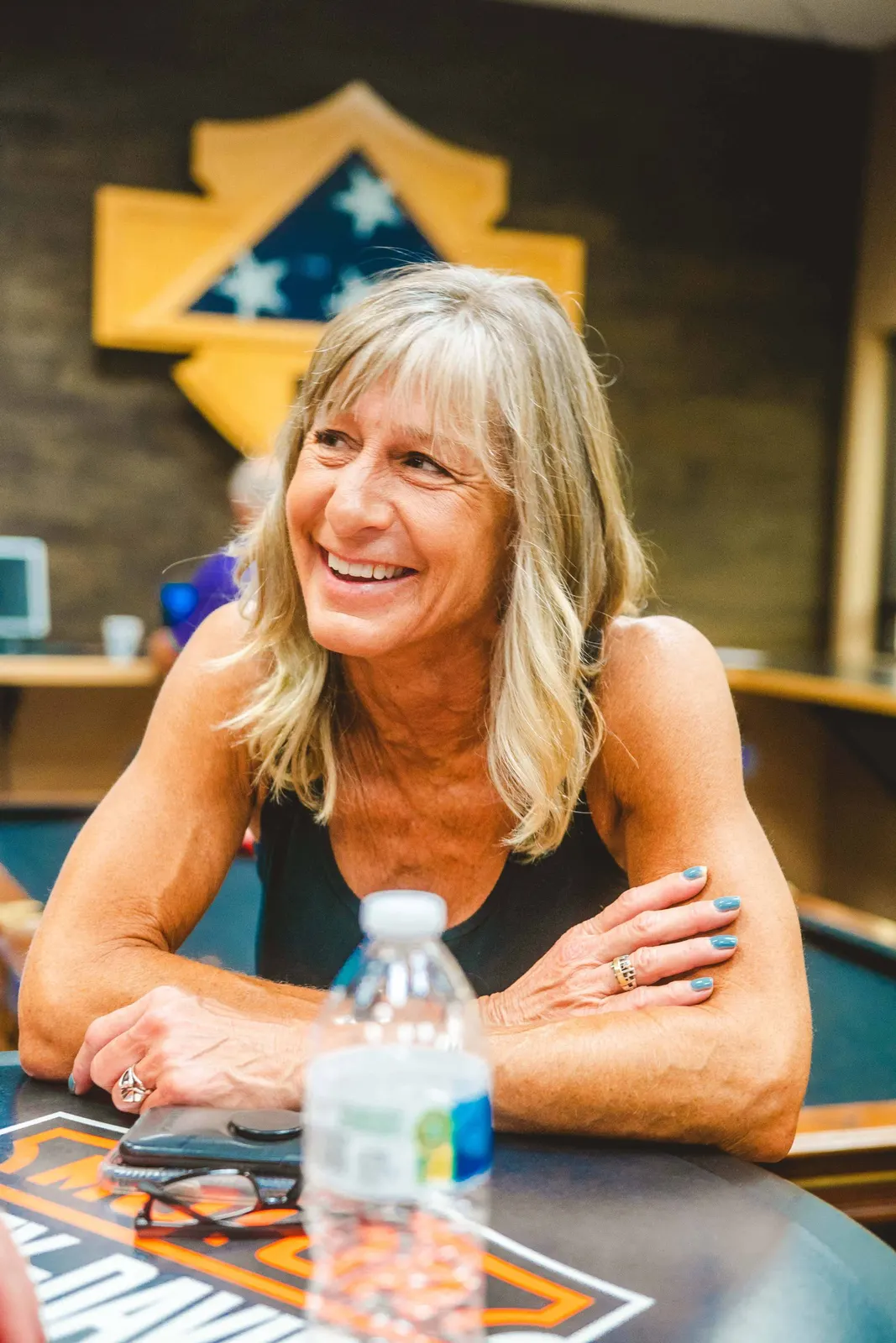 Woman smiling at a table indoors