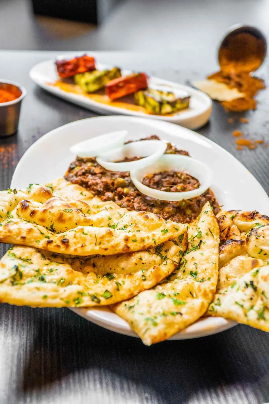 Plated flatbreads and side dishes on a table